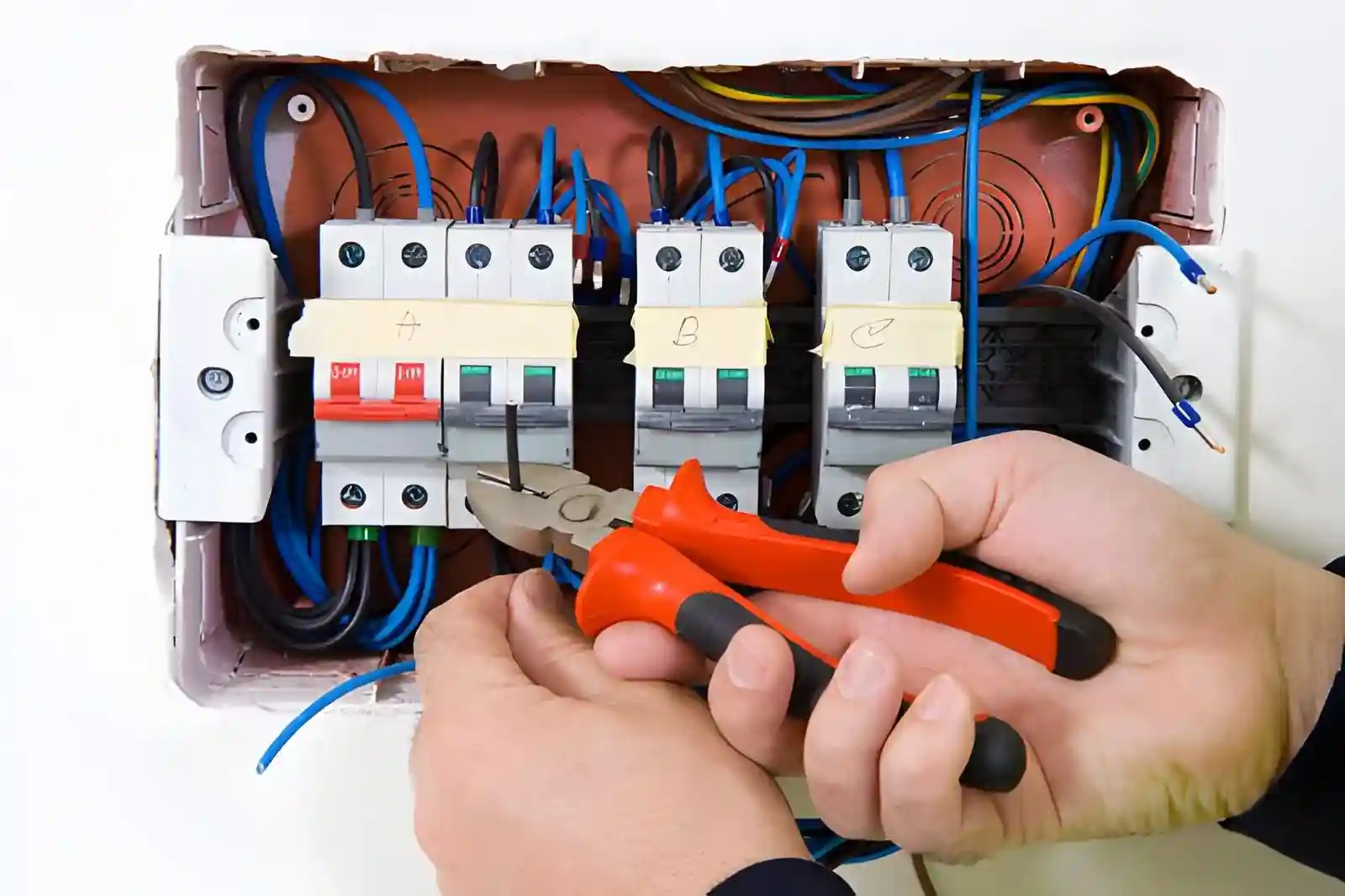 Electrician replacing a fuse box UK consumer unit in a home electrical panel